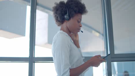 focused female operator in wired headset using cell