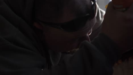 a man works inside remodeling a house - uses foam insulation on window