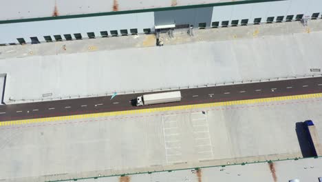 aerial shot of industrial warehouse loading dock where many truck with semi trailers load merchandise