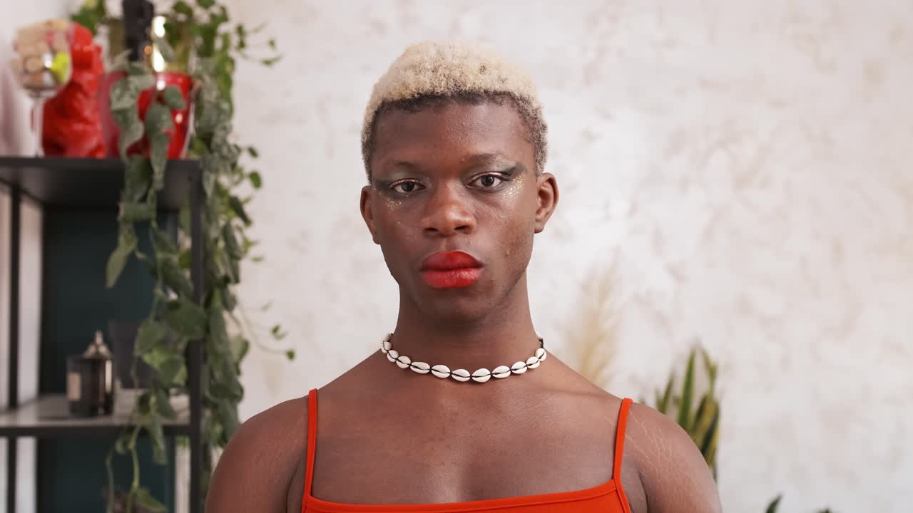 Close-up portrait of a person with blonde hair and bold makeup.