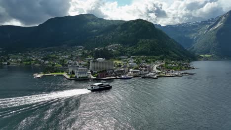 express catamaran arriving in epic village of balestrand in the sognefjord norway - summer panoramic aerial view