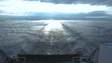 ship's wake on a cloudy winter ocean with sun reflection