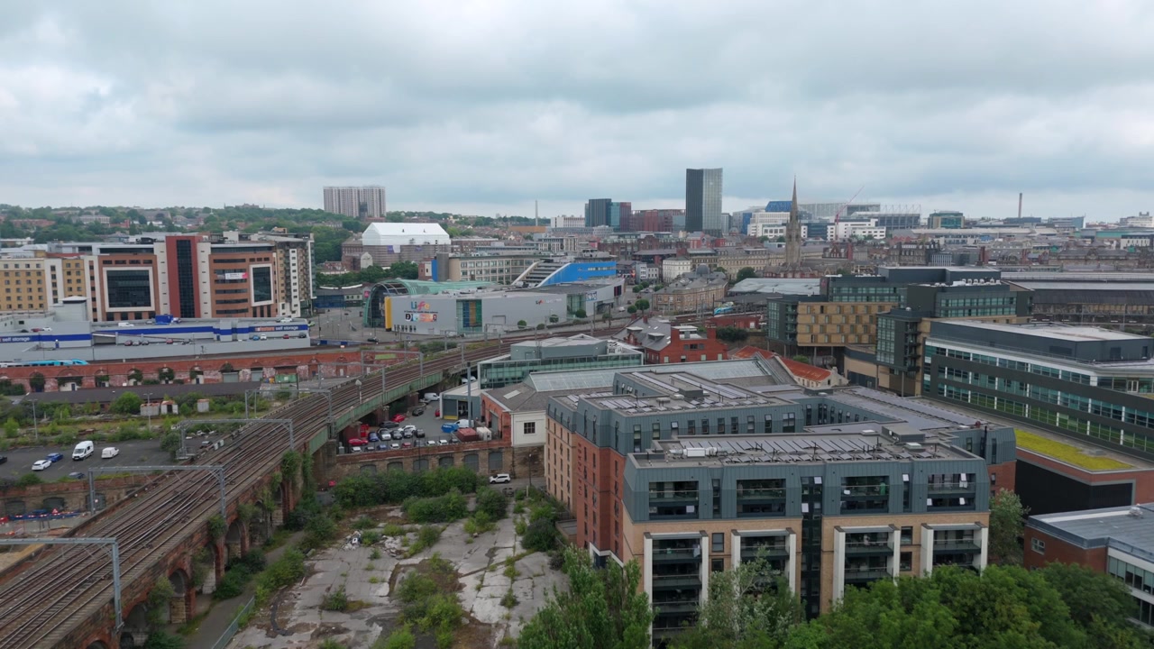 Vista Aérea de um Terreno Industrial Abandonado ao Lado de um Viaduto Ferroviário e do Horizonte Moderno de Newcastle, Inglaterra.
