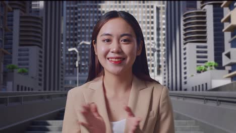 smiling business woman clapping in cityscape