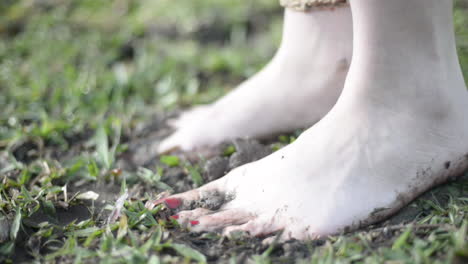 young woman´s feet stepping in mud and grass