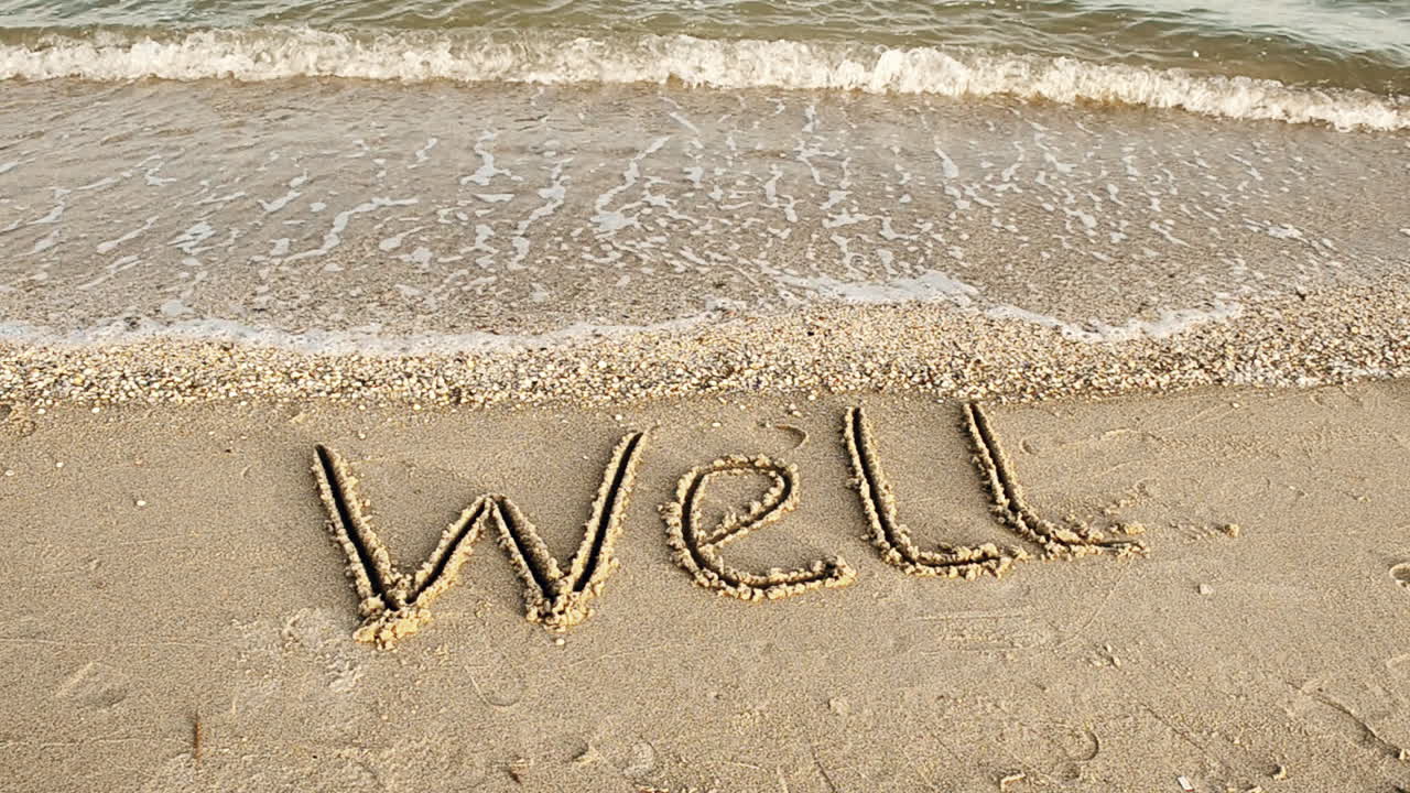 L'iscrizione BENE sulla sabbia. Ripresa sulla spiaggia