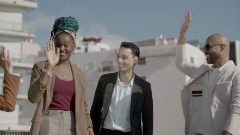 front view of happy diverse coworkers giving five to each other