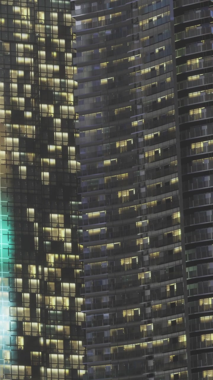 City buildings at night with lights in windows and varied designs