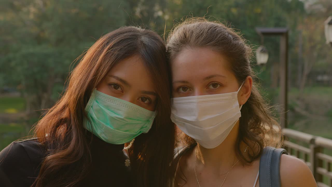 Two Women Wearing Masks in a Park