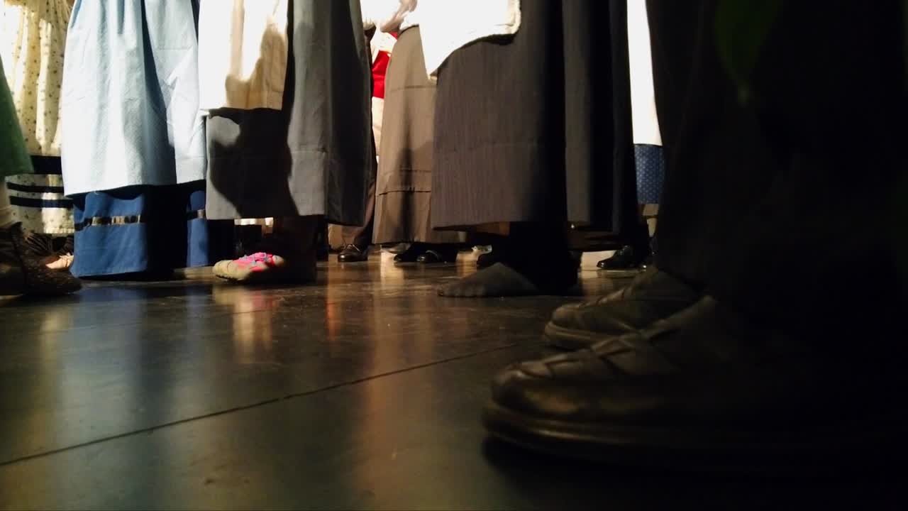 긴 전통 드레스를 입고 발을 두드리며 돌아다니는 사람들