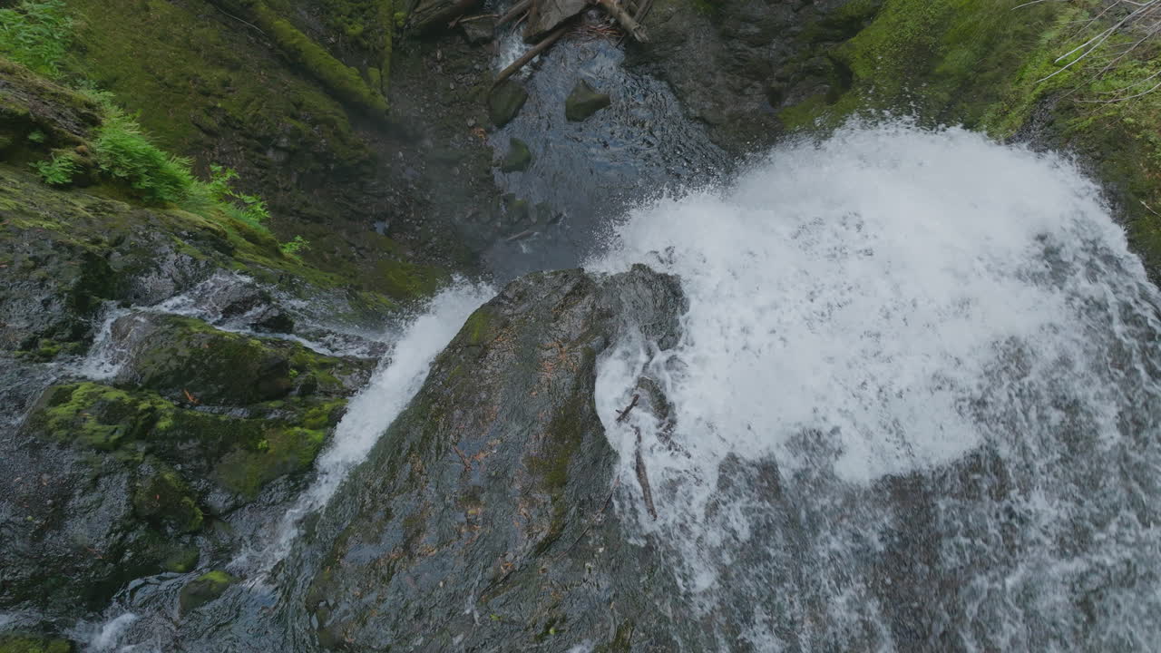 Top down view of Falls Creek Falls in Gifford Pinchot National Forest tumbling over top of rocky cliff.