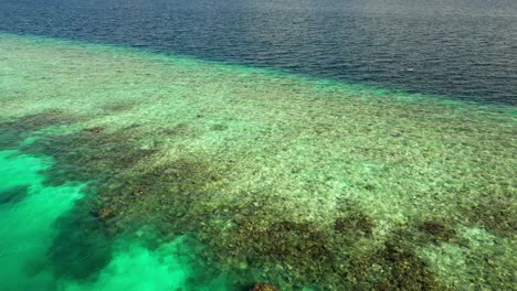 low aerial view across fasdhoo reef and into the lagoon