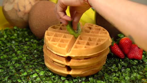 adding topping kiwi fruit on waffles in slow motion