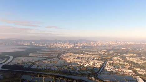 hong kong and shenzhen border line over hong kong rural houses with shenhzen skyline in the horizon, aerial view