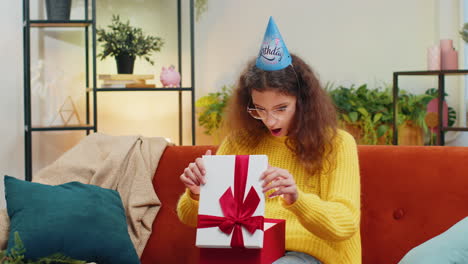 Niña-Feliz-Sostiene-Una-Caja-De-Regalo-De-Cumpleaños-Con-Cinta,-Celebrando-La-Fiesta,-Abriendo-El-Regalo-En-Casa