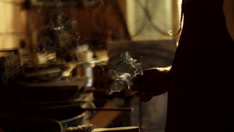 blacksmith smoking in a workshop
