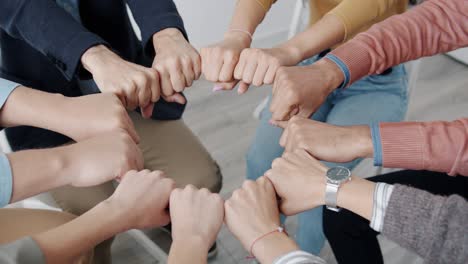 close-up of male and female hands in circle while people getting treatment at group therapy