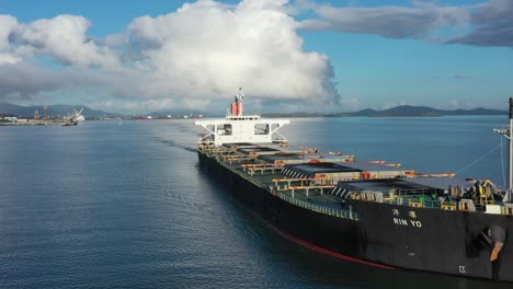 drone stationary shot of large coal ship leaving port, gladstone queensland australia