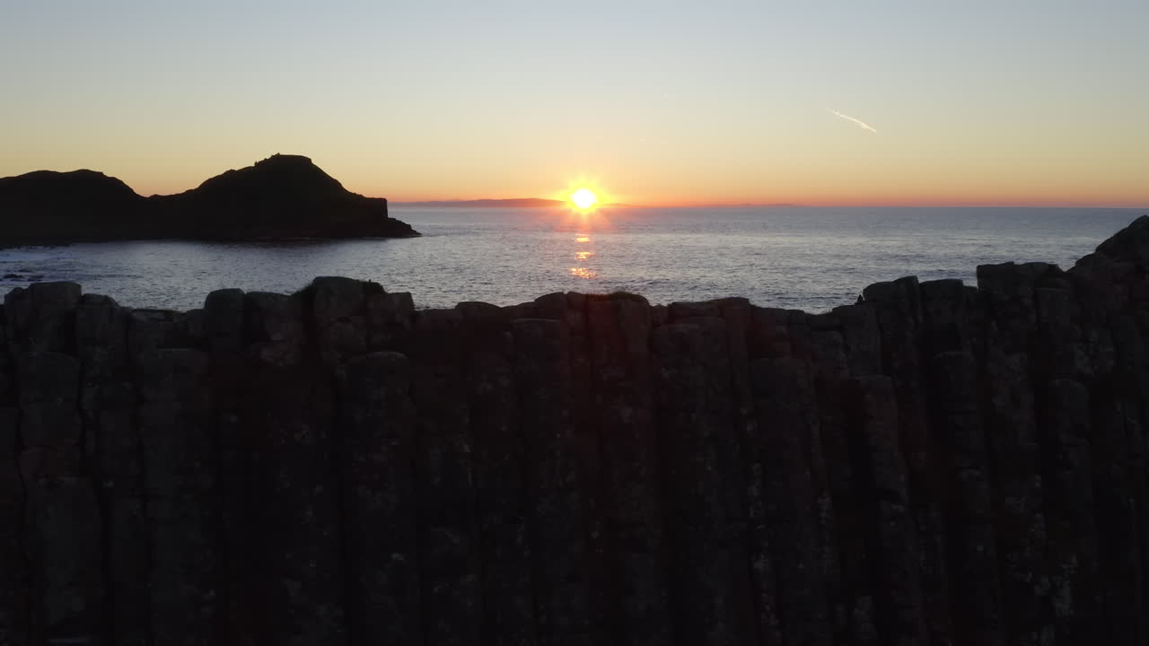 Betagende solnedgang over kystklipper og hav