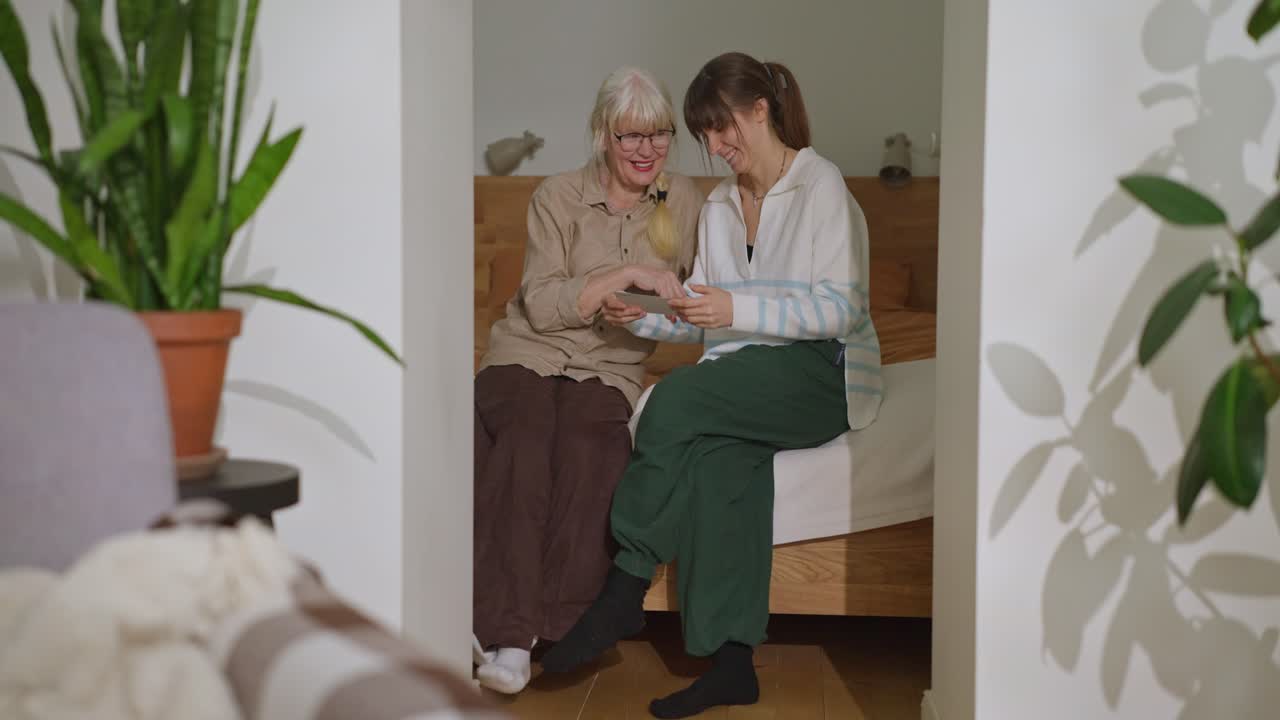 Two women are sitting and looking at something