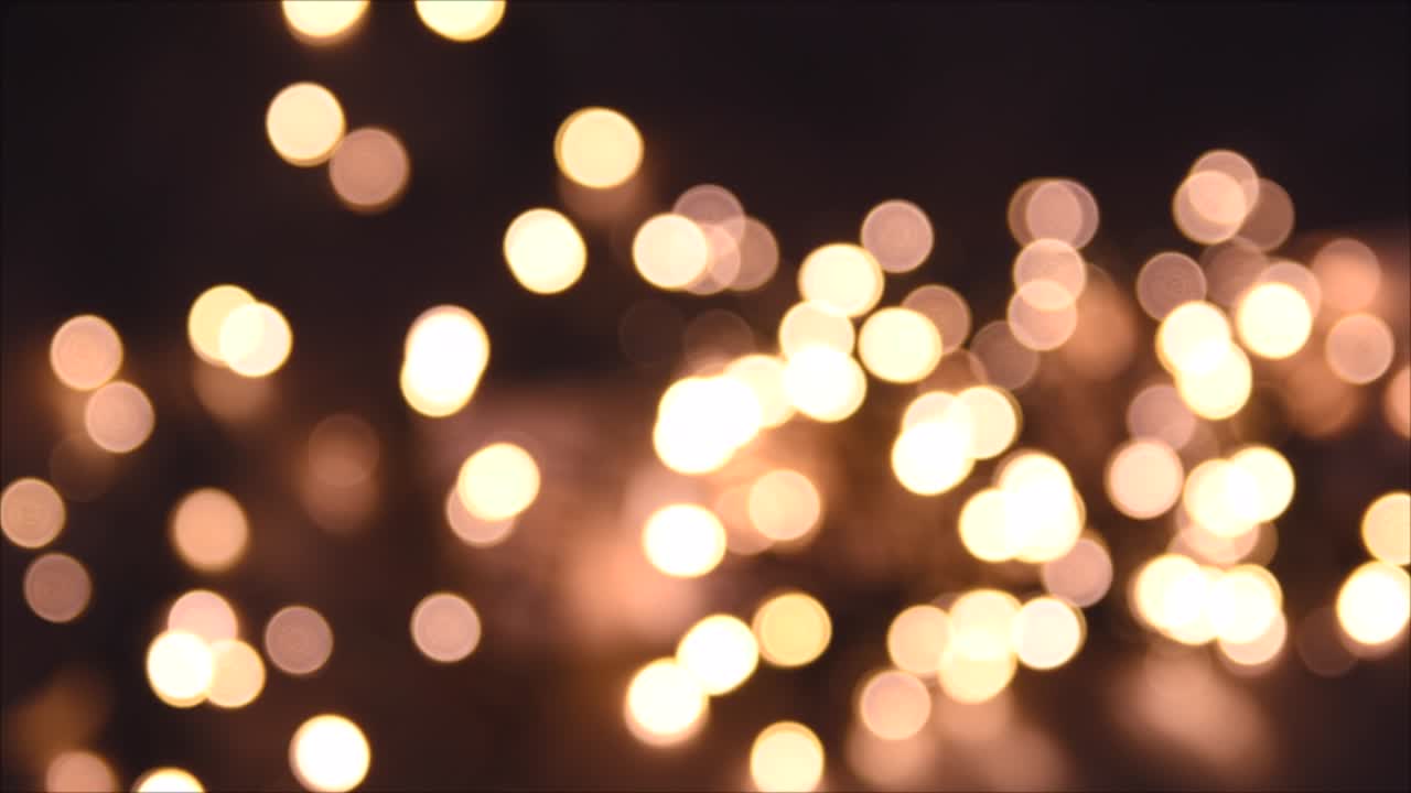 Christmas lights, shimmering abstract golden warm circles defocused. Blurred fairy lights. Out of focus holiday background. Light bokeh from Xmas tree. New Year theme, background 4k footage