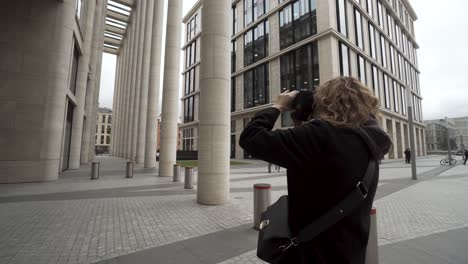 woman taking photo of office building