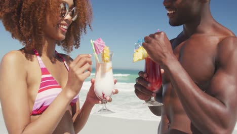 African-american-couple-drinking-cocktail-seaside