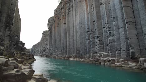 el río turquesa studlagil que fluye a través de un espectacular cañón de formaciones rocosas de basalto