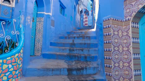 walking up stairs in the picturesque blue city, chefchaouen, morocco