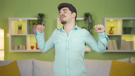 un joven cansado y somnoliento saludando a la cámara.
