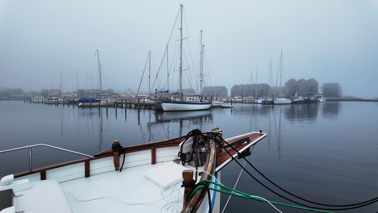 On a foggy day, many pleasure yachts and boats are moored in the harbor. Europe Denmark
