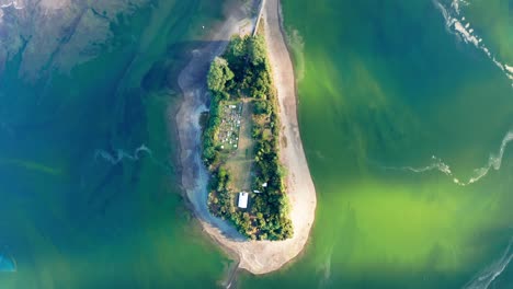 aerial birds eye view over aucar island connected to island of chiloe by wooden walkway