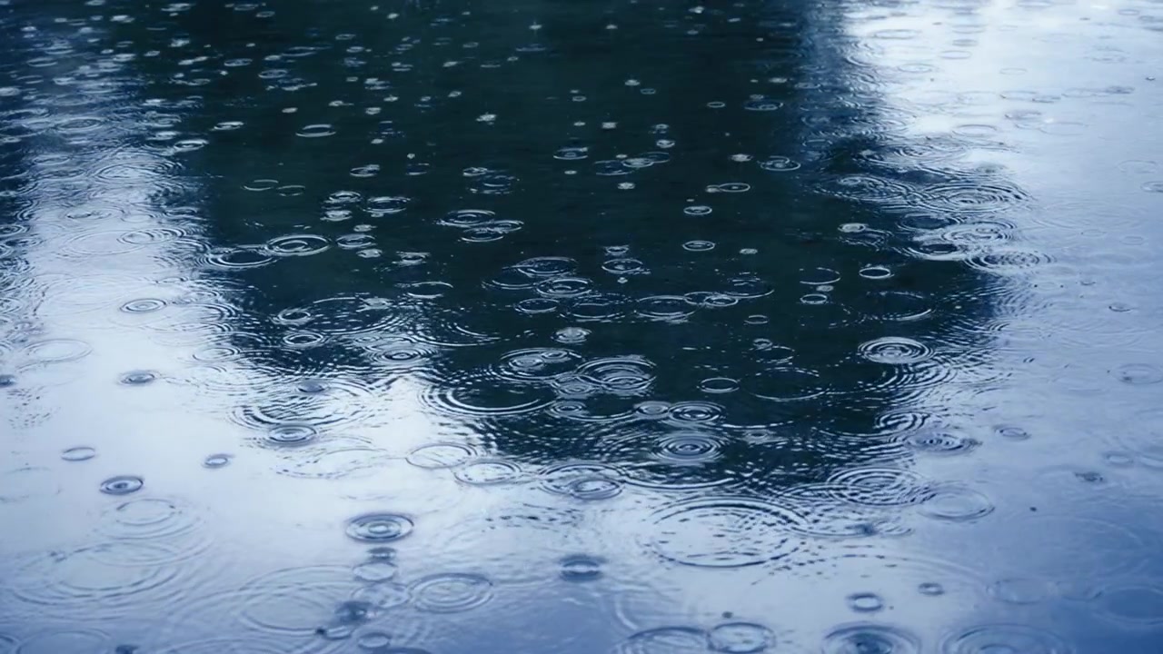 Rain drops of blue lake water surface