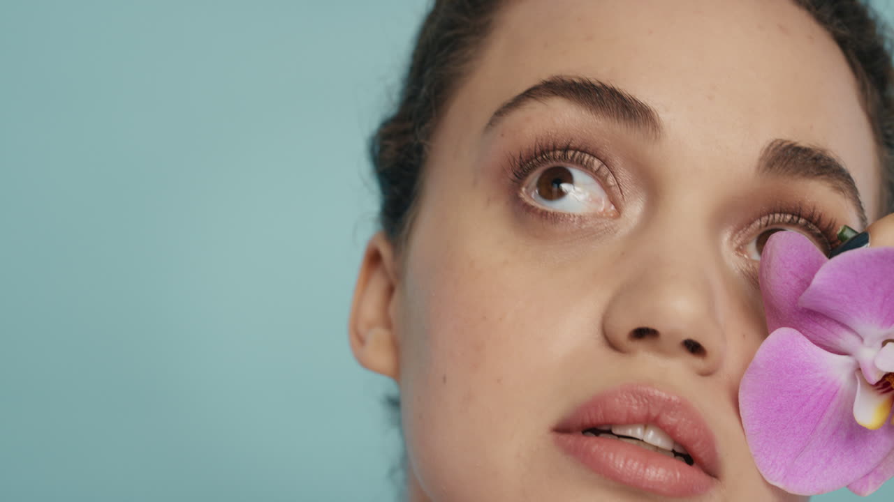 retrato de belleza de cerca mujer hermosa tocando el cuerpo con colorida flor de orquídea rosa acariciando suave piel sana tez disfrutando de fresa fragancia natural concepto de cuidado de la piel