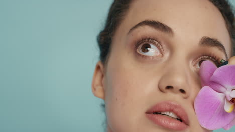 retrato de belleza de cerca mujer hermosa tocando el cuerpo con colorida flor de orquídea rosa acariciando suave piel sana tez disfrutando de fresa fragancia natural concepto de cuidado de la piel