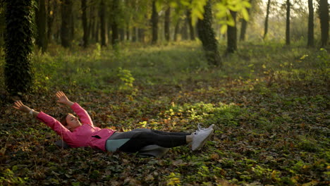 woman exercising core in a sunny autumn park