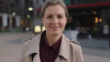 Retrato-De-Una-Mujer-De-Negocios-De-Mediana-Edad-Sonriendo-Feliz-Disfrutando-De-Los-Desplazamientos-Nocturnos-En-La-Ciudad-Con-Un-Abrigo-Elegante