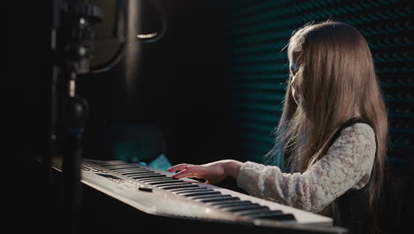 young girl playing piano in a recording studio