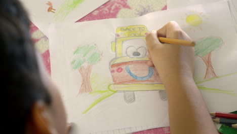 boy draws quietly lying in bedroom room at home. concentrated child doing school homework at weekend. concept of kids activities on vacations and family free time in childhood