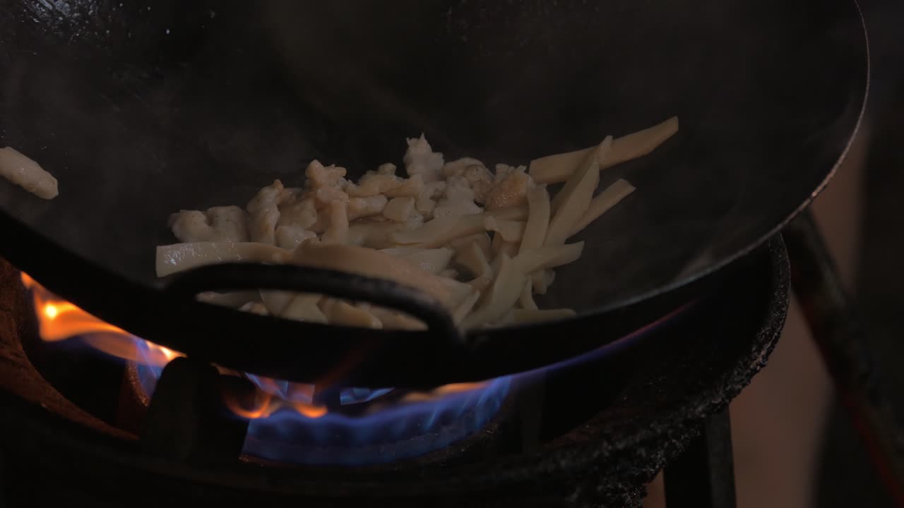 Preparazione di un piatto di noodles in wok su fuoco a gas, Thailandia