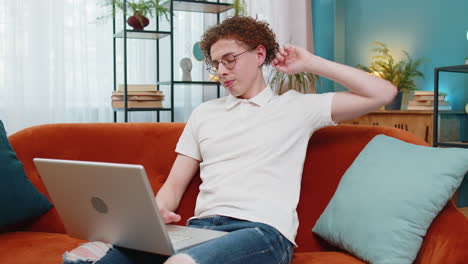 tired young male freelancer man using working laptop having problem tension stress, sends messages
