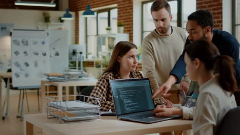 team of developers collaborating on code in an office