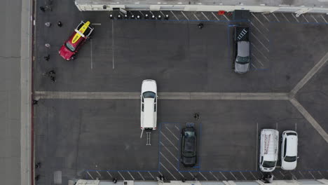 Aerial-drone-of-people-unloading-a-casket-from-a-white-hearse