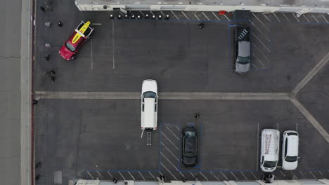 drone aéreo de personas descargando un ataúd de un coche fúnebre blanco