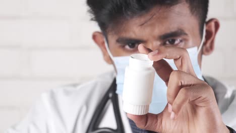 un médico examinando un frasco de medicamentos