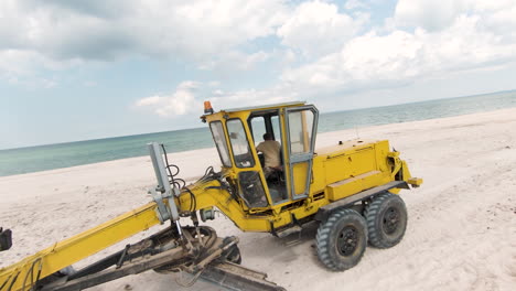 yellow bulldozer working on a beach