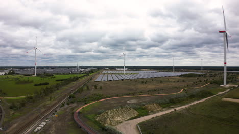 rural landscape with solar panels and turbines in belgium, aerial view