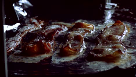 4 slices of bacon sizzling in the oven