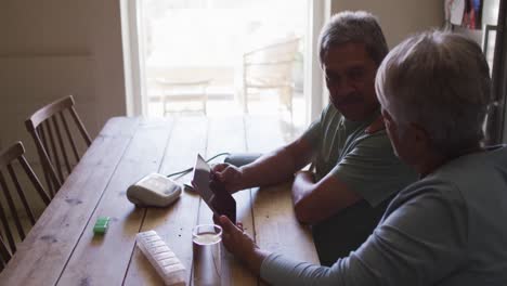 Senior-mixed-race-couple-having-online-medical-consultation-using-tablet