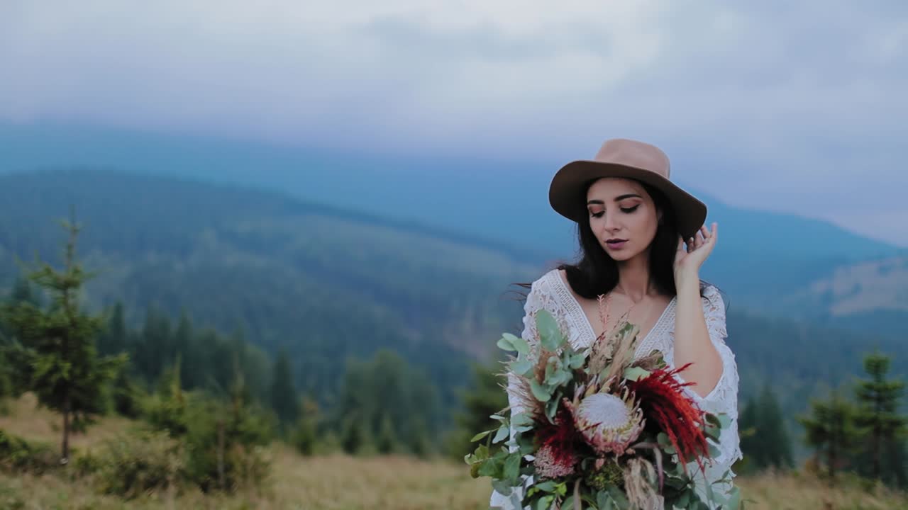 Bride posing near the mountains. Beautiful happy young bride posing on background of mountains